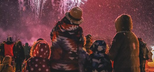 Mother and Father watching Fireworks with their Children on a snowy night.